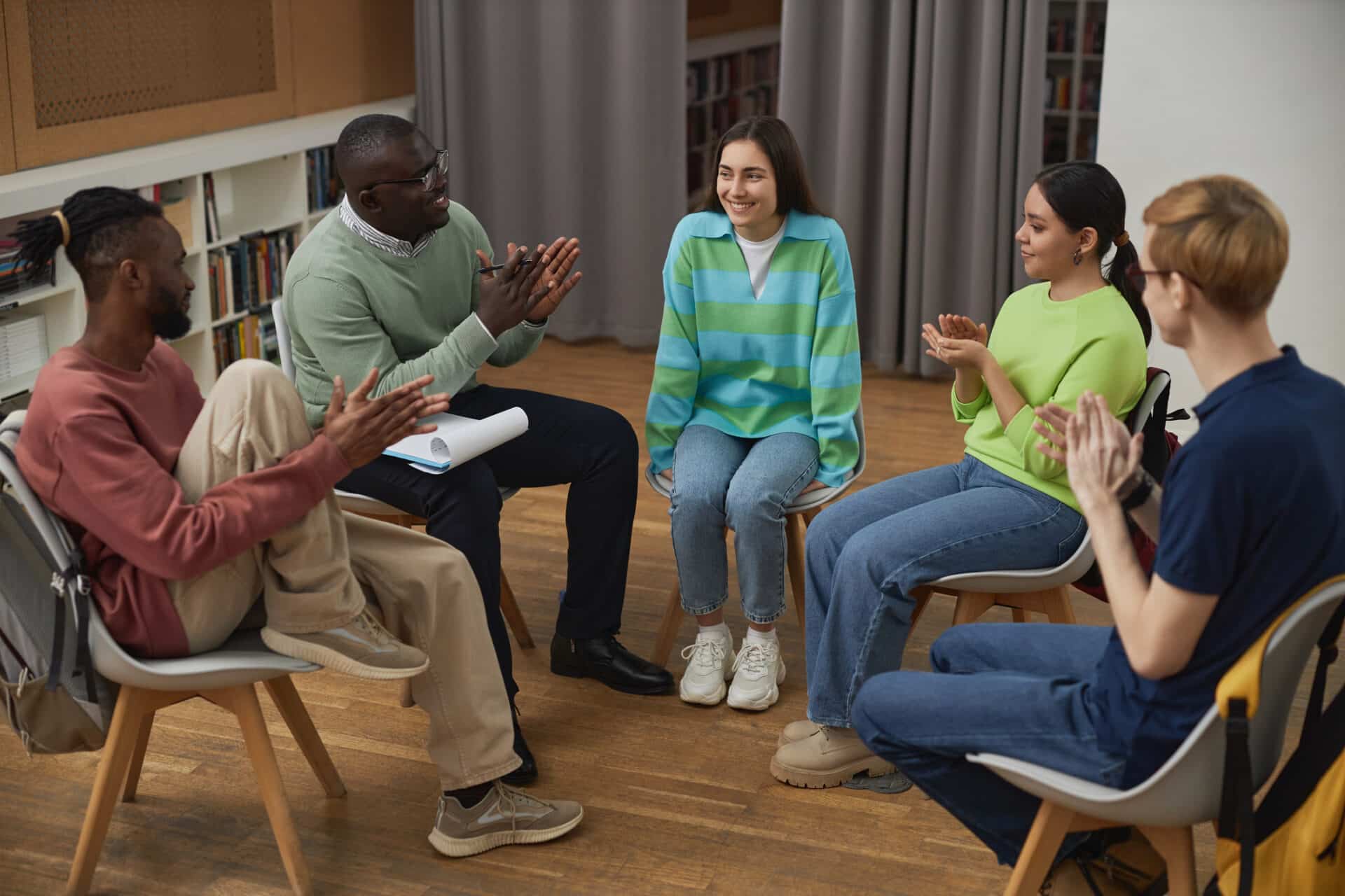 adult and teens sitting in chairs